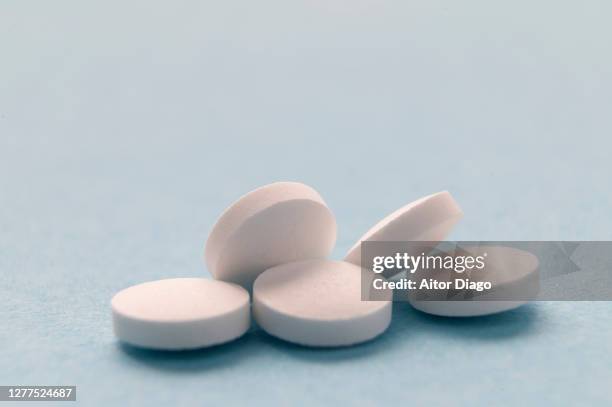 five pills on a blue desk. - paracetamol stock-fotos und bilder