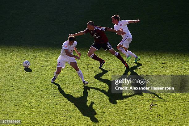 Timmy Simons of Nuernberg battles for the ball with Nicolai Mueller of Mainz and his team mate Andreas Ivanschitz during the Bundesliga match between...