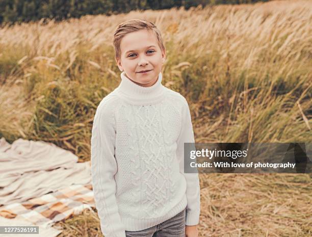 10-12 year old boy walking outdoors enjoying autumn season in a village - september 12 stock pictures, royalty-free photos & images