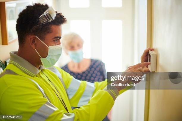 covid ingeniero de calefacción segura - thermostat fotografías e imágenes de stock