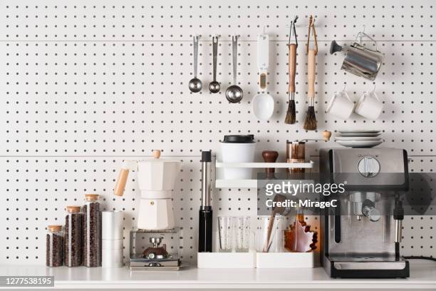 espresso coffee maker and accessories on pegboard - arrangiare foto e immagini stock