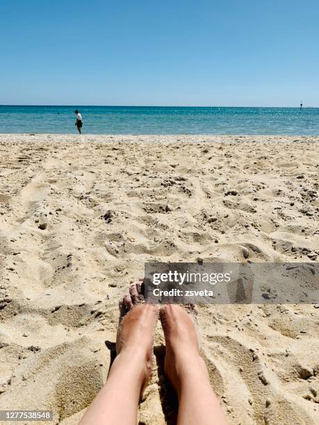 enjoying sunny weather on the beach - hot legs stock pictures, royalty-free photos & images