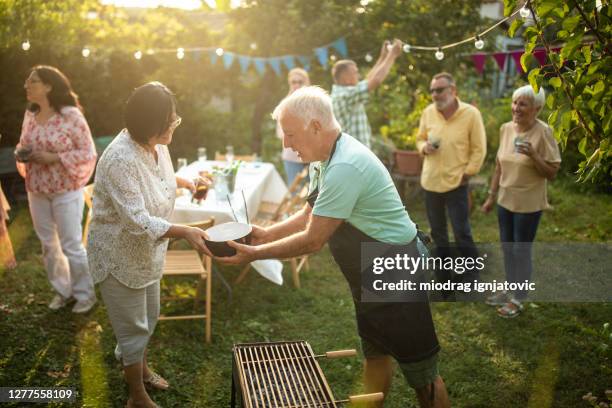 senior freunde genießen qualität zeit zusammen im hinterhof während schönen tag - neighbors stock-fotos und bilder