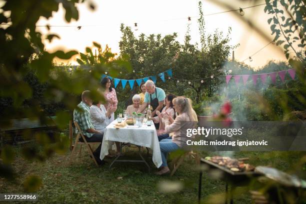 vrienden en familie die de verjaardag van oma bij binnenplaats vieren - buren stockfoto's en -beelden