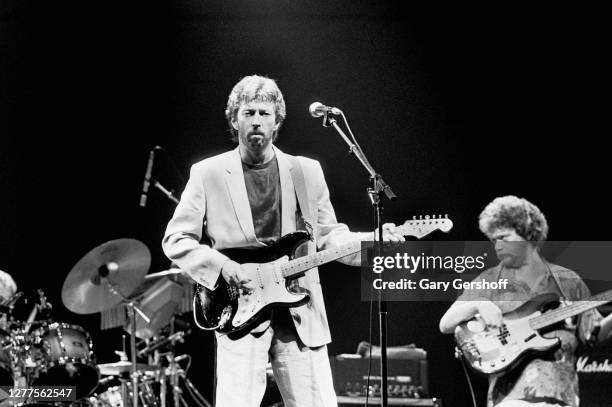 British Rock and Blues musician Eric Clapton plays guitar as he performs onstage during his 'Behind the Sun' tour at Brendan Byrne Arena , East...