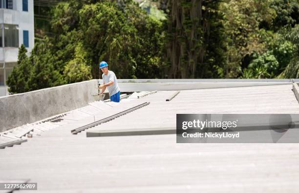 mason worker repairing rooftop leakage - telhado imagens e fotografias de stock