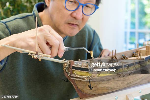 pensionering hobby leisure - het bouwen van houten schip kit model - building model stockfoto's en -beelden