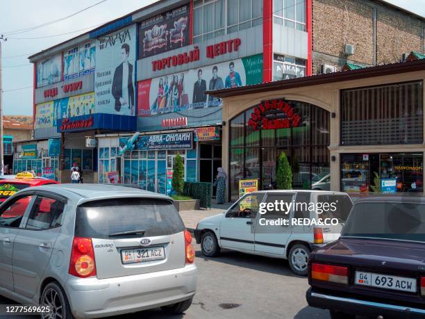 Street with cars and shops. City Jalal-Abad in the Fergana Valley close to the border to Uzbekistan. Asia. Central Asia. Kyrgyzstan.