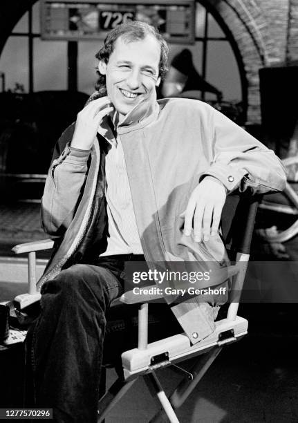 View of English Rock and Blues musician Mark Knopfler, of the group Dire Straits, as he sits in a director's chair during an interview at MTV...