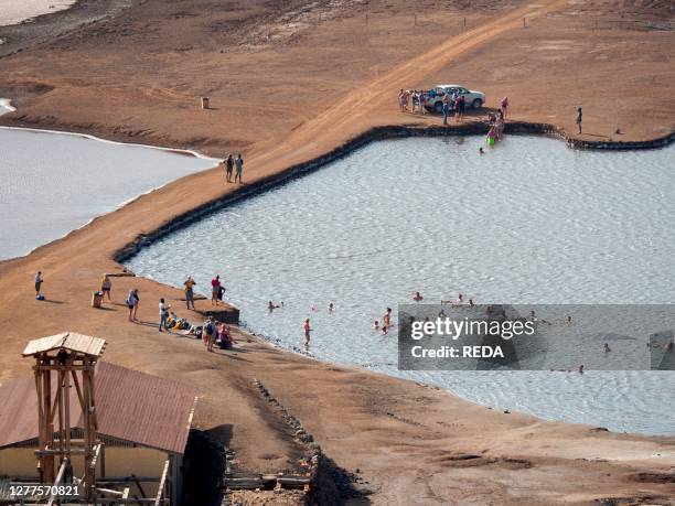 Tourists swimming in salty water. Salt vulcano near Pedra de Lume The island Sal. Cape Verde. An archipelago in the equatorial atlantic in Africa..