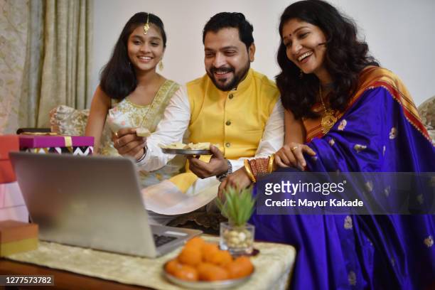 family wishing happy diwali to their friends and relatives over a video call - diwali greetings stock pictures, royalty-free photos & images