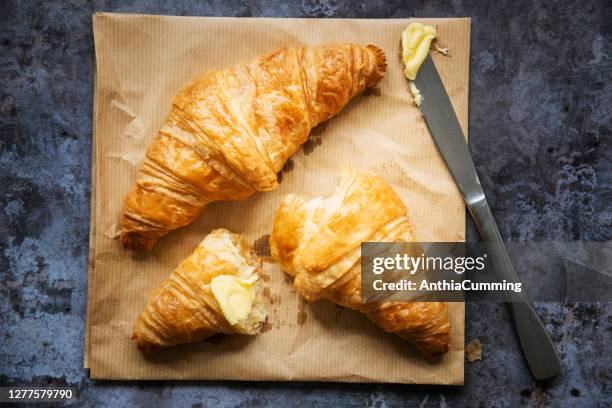 dos croissants franceses recién horneados con mantequilla y un cuchillo - untar de mantequilla fotografías e imágenes de stock