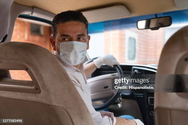 motorista usando uma máscara facial e luvas em seu carro - driving mask - fotografias e filmes do acervo