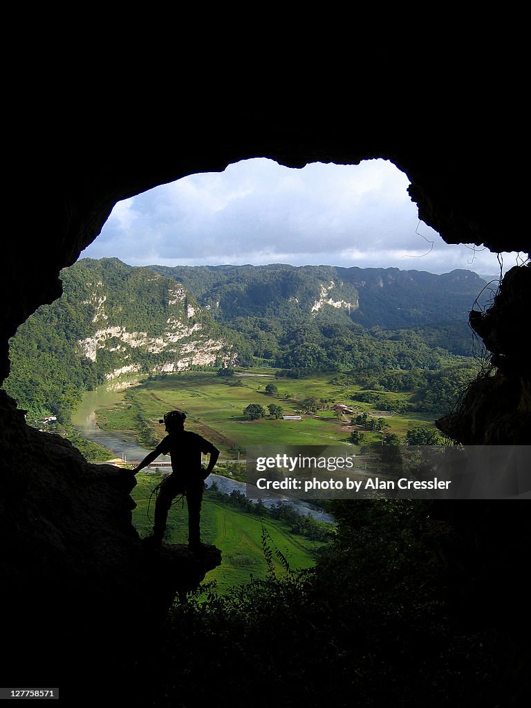 Man standing on entrance of cave