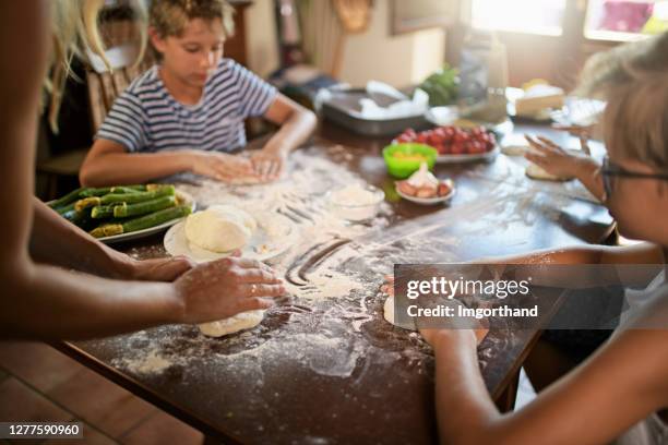 family having fun preparing homemade pizza - make room make room stock pictures, royalty-free photos & images