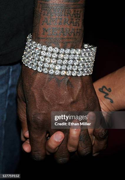 Former NBA player Shaquille O'Neal and his girlfriend Nicole "Hoopz" Alexander hold hands as they arrive at his retirement party at Moon nightclub at...