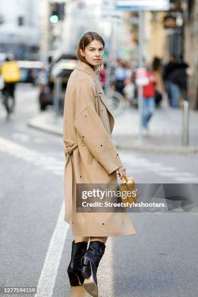 Influencer Jacqueline Zelwis, wearing a beige coat by Lala Berlin, an animal printed dress by Lala Berlin, black boots by Fendi and a dark yellow bag...