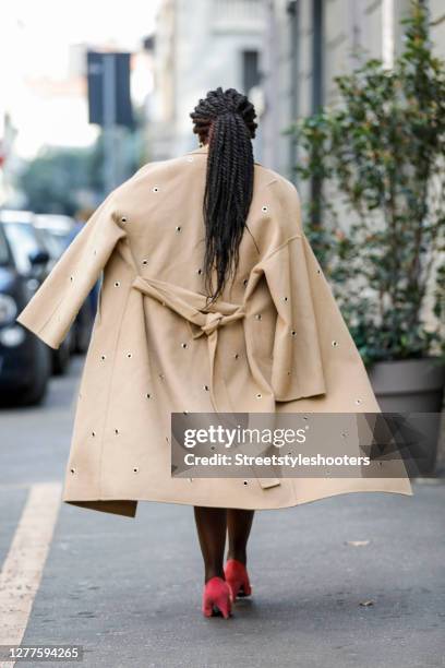 Influencer Lois Opoku, wearing a beige coat with ponted cutouts by Lala Berlin and pink pumps by topshop, is seen during the Milan Women's Fashion...