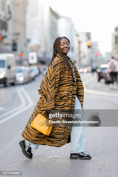 Influencer Lois Opoku, wearing a tiger colored coat with tiger pattern by Lala Berlin, a tiger colored shirt with tiger pattern by Lala Berlin, a...