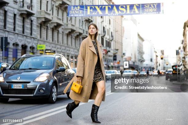 Influencer Jacqueline Zelwis, wearing a beige coat by Lala Berlin, an animal printed dress by Lala Berlin, black boots by Fendi and a dark yellow bag...