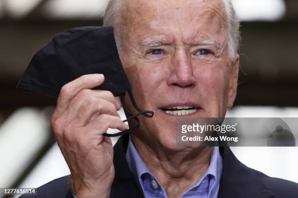 Democratic presidential nominee Joe Biden holds up a mask as he speaks during a campaign stop at Pittsburgh Union Station September 30, 2020 in...