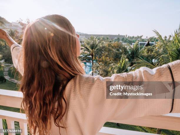 frau arme bei sonnenaufgang vom balkon geöffnet - open arms stock-fotos und bilder