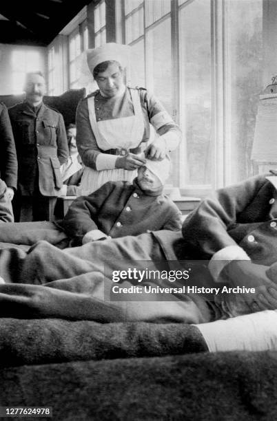 Nurse bandaging Head of Soldier at Canadian Base Hospital during World War I, Hotel du Golf, Le Touquet, France, Bain News Service, 1914.
