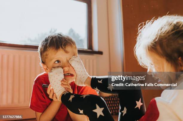 sister sticks her feet in her brothers face - sfida foto e immagini stock