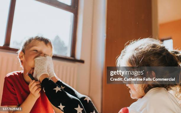 sister and brother causing mischief - male feet on face stock pictures, royalty-free photos & images