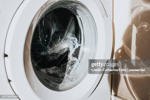 close-up on a white washing machine - clothing tag stock pictures, royalty-free photos & images