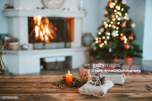 schön weihnachtlich dekorierte inneneinrichtung mit einem weihnachtsbaum und weihnachtsgeschenke - table stock-fotos und bilder