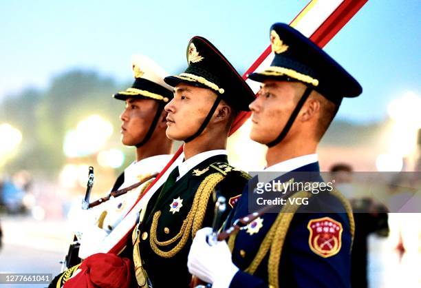 Soldiers of the People's Liberation Army honor guard escort the national flag from the Forbidden City to Tian'anmen Square during the flag-raising...