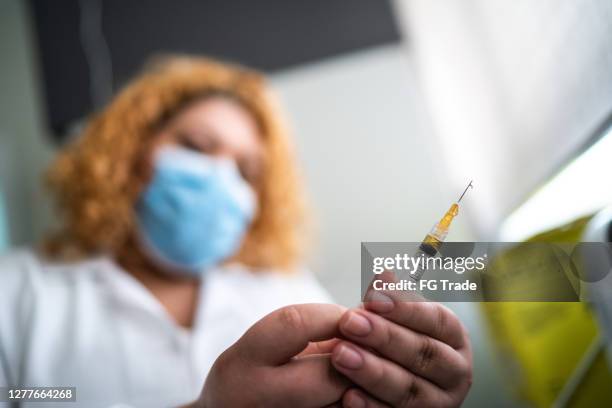 female nurse preparing vaccine - yellow fever stock pictures, royalty-free photos & images