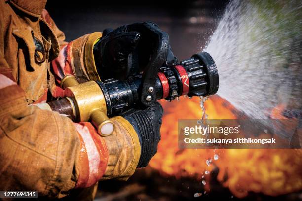 firefighters extinguishing house fire. - brandde stockfoto's en -beelden