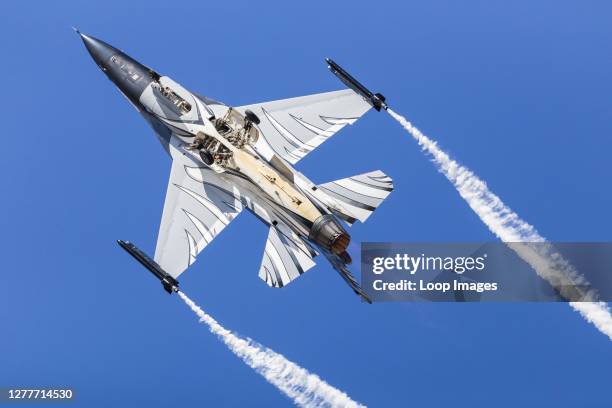 Belgian Air Component F-16AM performing under a blue sky.