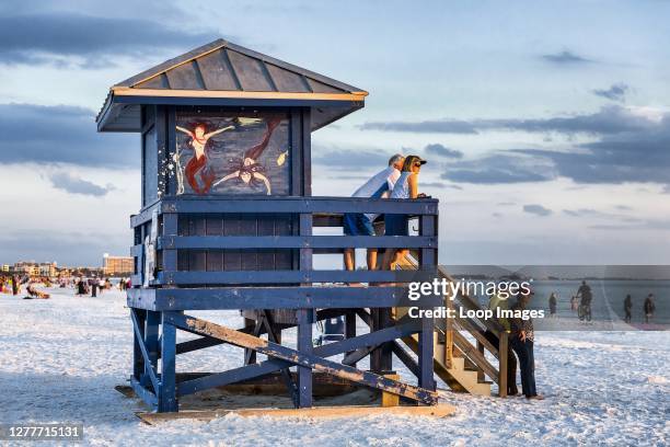 Tourists enjoy sunset view at Siesta Key Beach in Florida.