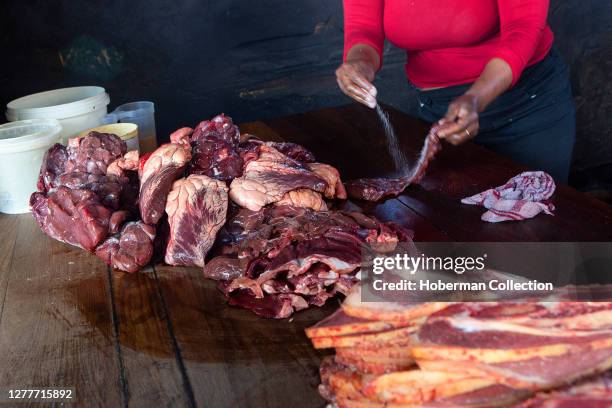 Woman salting meat for 'Shisenyama' , Johannesburg, South Africa