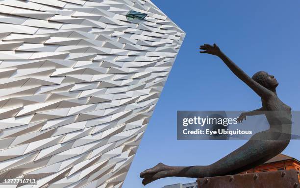 Ireland, North, Belfast, Titanic Quarter, Visitor centre designed by Civic Arts & Eric R Kuhne, with statue of diving woman in foreground.