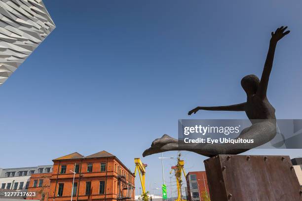 Ireland, North, Belfast, Titanic Quarter, Visitor centre designed by Civic Arts & Eric R Kuhne, with statue of diving woman in foreground.