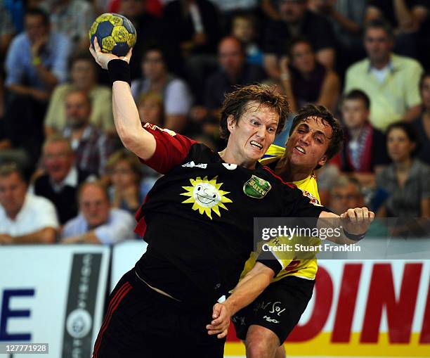 Frank Loke of Luebbecke is challenged by Nils Eichenberger of Hildesheim during the Toyota Handball Bundesliga match between TuS N-Luebbecke and...