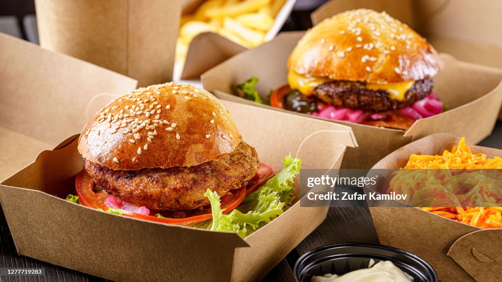 Comida callejera. Las hamburguesas de chuletas de carne están en cajas de papel. Entrega de alimentos.