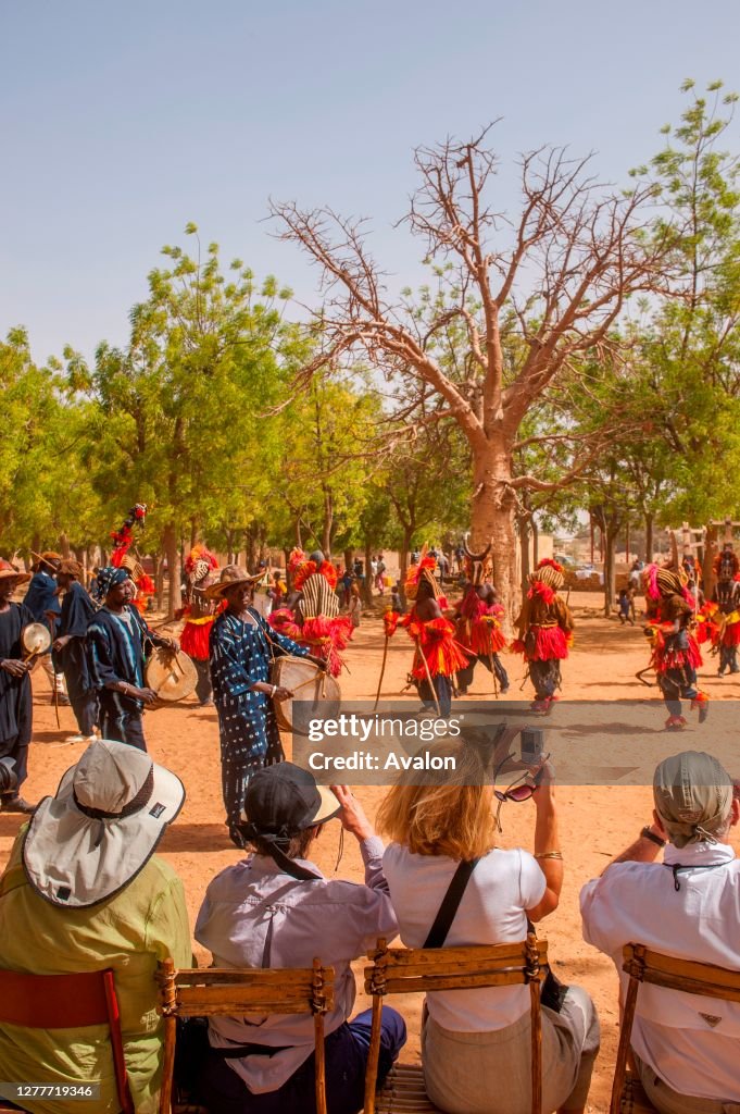 Tourists watching the traditional dances of the Dogon people in the village of Sangha in the Dogon country in Mali, West Africa.