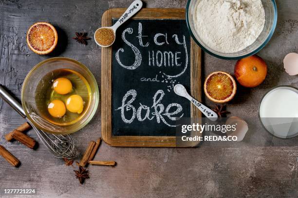 Ingredients for baking. Stay home quarantine isolation period concept. Vintage chalkboard with handwritten chalk lettering Stay home and bake. Grey...