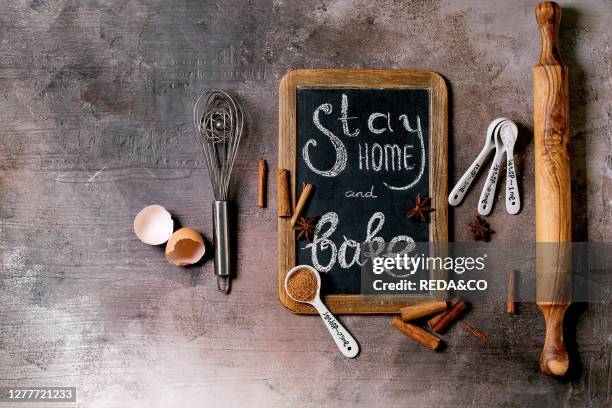 Ingredients and tools for baking. Stay home quarantine isolation period concept. Vintage chalkboard with handwritten chalk lettering Stay home and...