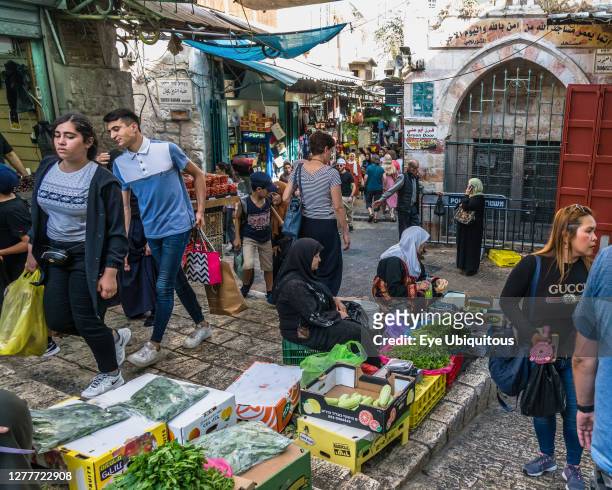 Israel, Jerusalem, Palestinian Arab women in tradtional dress sell produce in the street market by the Damascus Gate in the Muslim Quarter of the Old...