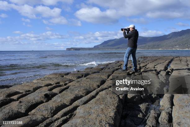 Travel photographer photographing Tessellated Pavement in Tasman Peninsula Tasmania Australia.
