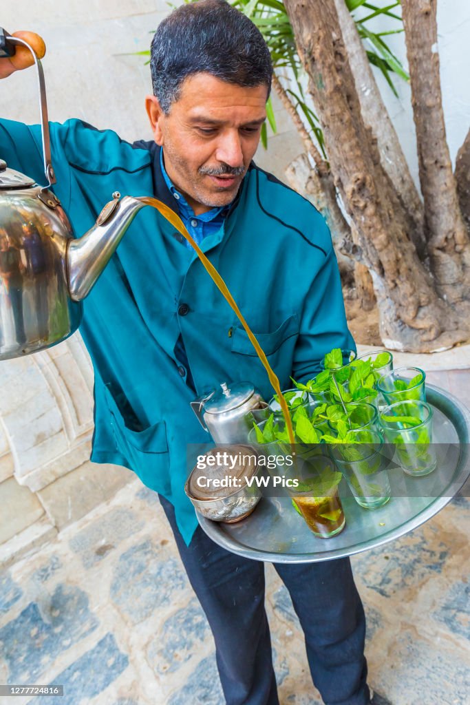 Man pouring mint tea at medina. Tunis city. Tunisia.