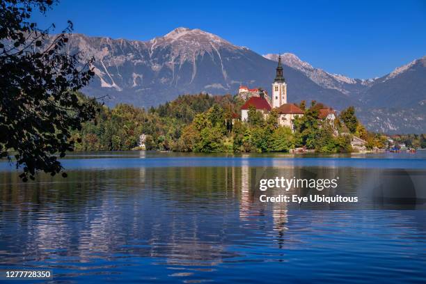 Slovenia, Upper Carniola, Bled, Bled Island and the Church of the Annunciation from the lake shore with Bled Castle in the background.