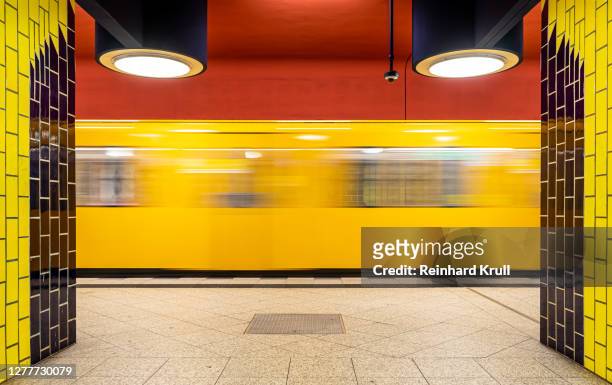 blurred motion of train at subway station - berlin stock-fotos und bilder