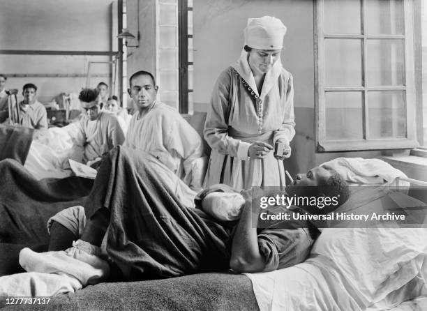 Injured American Soldier receiving Cigarette from American Red Cross Worker at Base Hospital 41, St. Denis, France, Lewis Wickes Hine, American...
